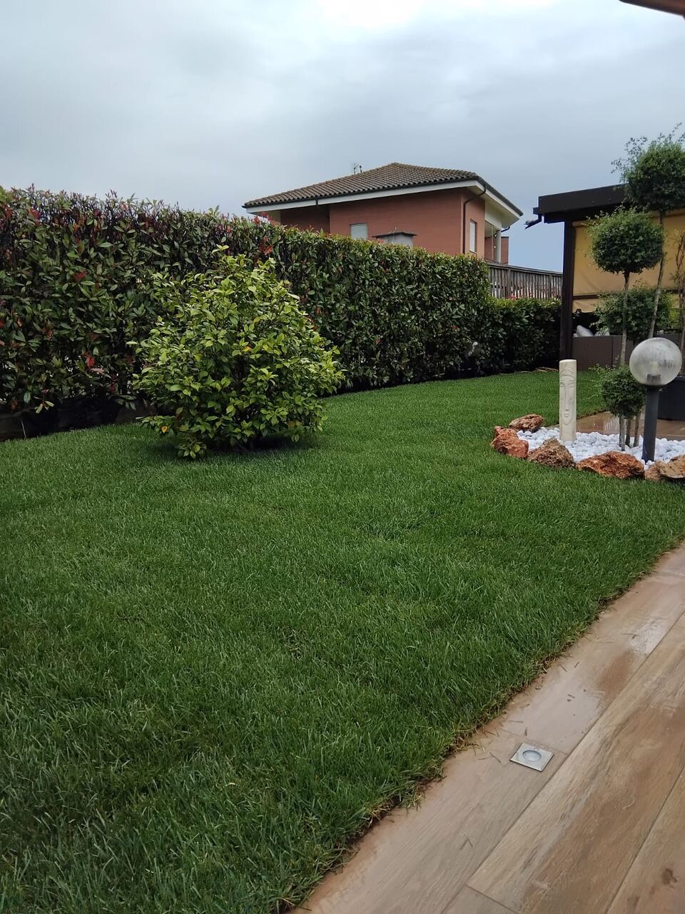 Prato curato tra siepi e aiuole in un giardino privato