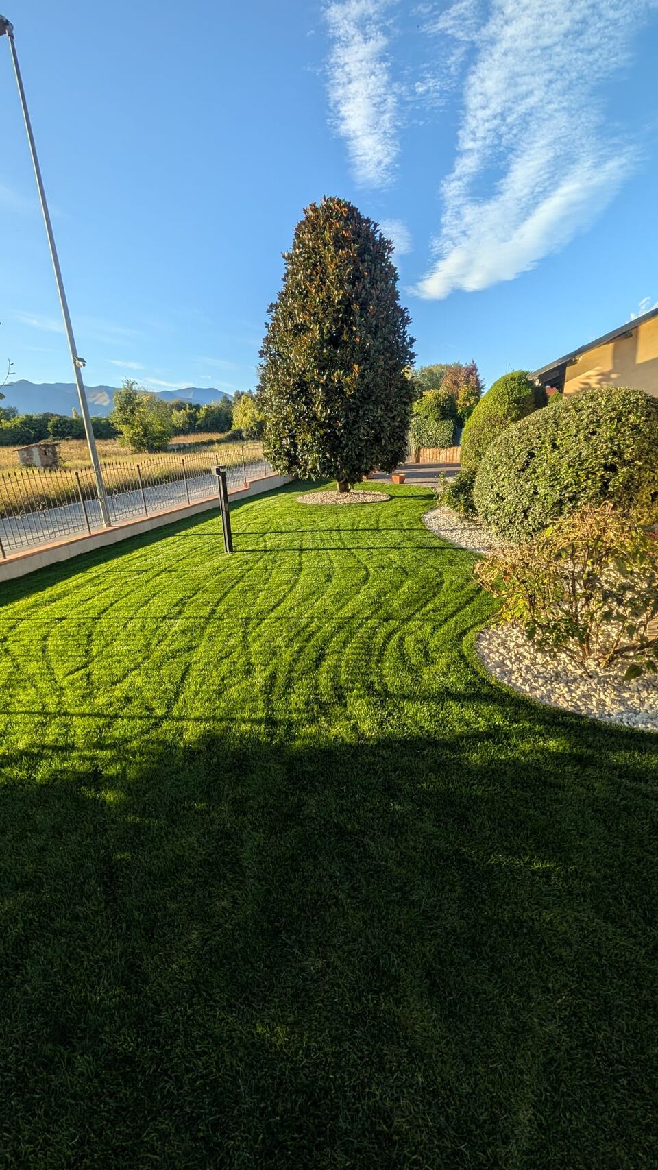 Irrigazione attiva su un prato lungo un vialetto